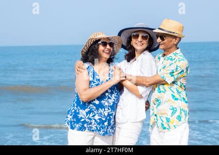 Glückliches älteres indisches Paar mit einer jungen Tochter, das den Urlaub am Strand genießt. Familie hat Spaß im Freien. Stockfoto