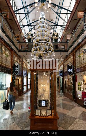 Eine einzige weibliche Weihnachtseinkäuferin spaziert entlang der Brisbane Arcade und genießt das Ambiente einer der berühmtesten Einkaufspassagen der Stadt Brisbane. Stockfoto