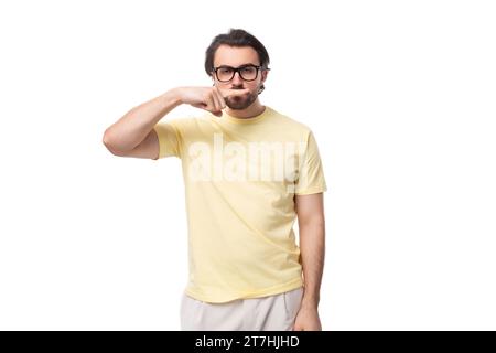 Junger kaukasischer Mann mit schwarzem Haar und Bart zeigt Grimasse Stockfoto