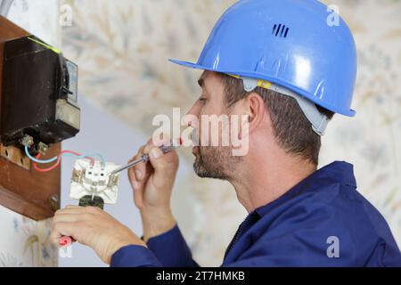 Männlicher Techniker, der mit der Steckdose arbeitet Stockfoto
