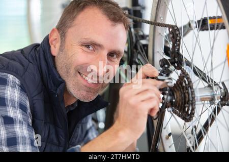 Mann Zweiradmechaniker Fahrräder reparieren Stockfoto