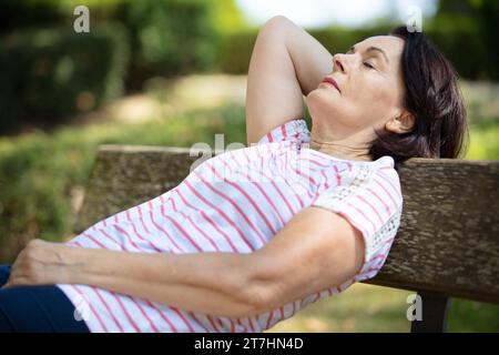 Die Seniorin schläft im Park Stockfoto