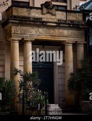 Ein altes Gebäude in Australien mit den Worten „Young Australian Bank“ auf der Fassade, umgeben von Bäumen und Vegetation Stockfoto