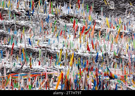 Farbenfrohe tibetische Flaggen in Tagong in Sichuan erzeugen wunderschöne Farbkontraste vor dem Hintergrund des schneebedeckten Berges Stockfoto