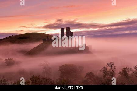Corfe Castle in Dorset an einem nebligen, nebeligen Morgen bei Sonnenaufgang Stockfoto