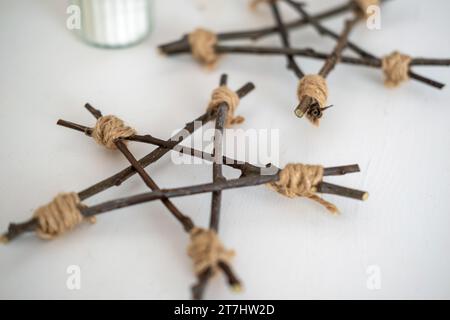 Simple Twig Star. DIY Star Tree Topper. Handgefertigte Weihnachtsdekoration. Einfache Idee von hölzernem Weihnachtsdekor. Skandinavisches, Boho-Skandinavisches Design. Einzigartig Stockfoto