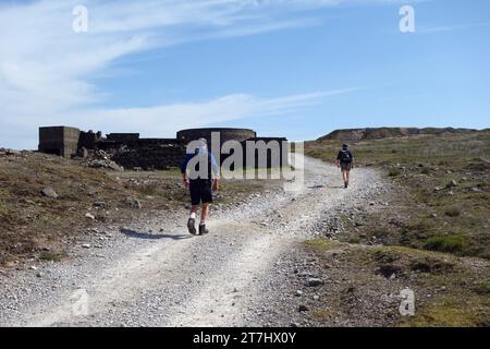 Two Men (Wanderer) Walking on a Track by the High Grinding Mill in den stillgelegten Grassington Lead Mines im Yorkshire Dales National Park, England, Großbritannien. Stockfoto