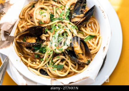 Eine Schüssel Spaghetti und Muscheln in cremiger weißer Sauce auf einem Tisch Stockfoto
