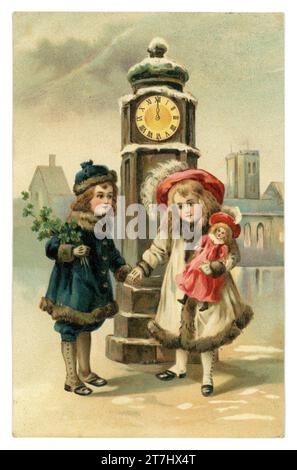 Originell, charmant, Anfang der 1900er Jahre Deutsch Happy New Year Grüße viel Glück Postkarte, zwei niedliche Kinder, vielleicht Bruder und Schwester, gekleidet in Pelzmäntel und Hüte treffen sich unter einem Uhrturm um Mitternacht, der Junge hält einen Blumenstrauß von Glücksklever, das Mädchen eine Puppe, gepostet / datiert 1912, Deutschland, Europa. Stockfoto