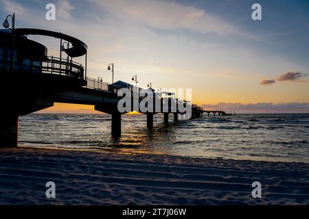 Pier am Strand in der Nähe von Misdroy in Polen. Natürlicher Küstenabschnitt an der polnischen Ostsee. Landschaft am Meer mit Sonnenuntergang am Pier. Stockfoto