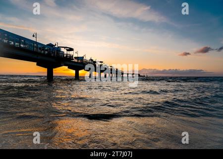 Pier am Strand in der Nähe von Misdroy in Polen. Natürlicher Küstenabschnitt an der polnischen Ostsee. Landschaft am Meer mit Sonnenuntergang am Pier. Stockfoto