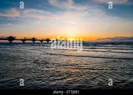 Pier am Strand in der Nähe von Misdroy in Polen. Natürlicher Küstenabschnitt an der polnischen Ostsee. Landschaft am Meer mit Sonnenuntergang am Pier. Stockfoto