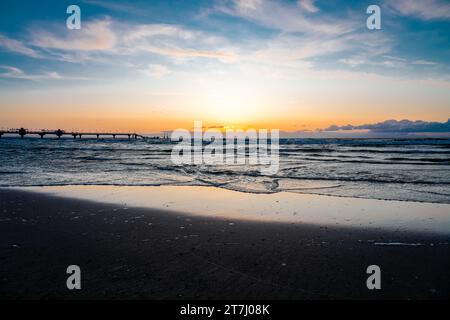Pier am Strand in der Nähe von Misdroy in Polen. Natürlicher Küstenabschnitt an der polnischen Ostsee. Landschaft am Meer mit Sonnenuntergang am Pier. Stockfoto