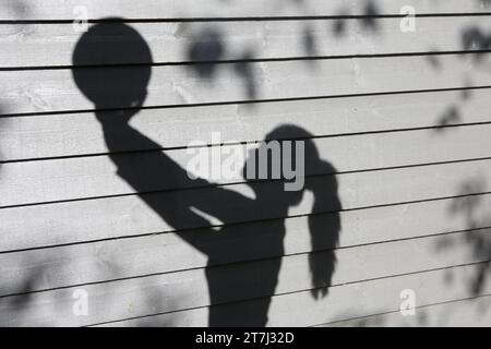 Das Teenager-Mädchen hält Volleyball mit beiden Händen Schatten und hält den Ball hoch im Copyspace Stockfoto