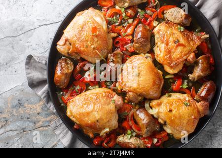 Chicken Scarpariello Klassiker, der Huhn, Zwiebeln, Wurst und scharfe Kirschpaprika kombiniert, alles in einer scharfen Essigsauce auf dem Teller auf t Stockfoto