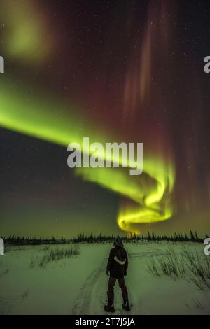 Ein aurora Selfie unter dem Bogen der Nordlichter am 22. Februar 2023 auf dem Weg vor dem Churchill Northern Studies Centre in Churchill, Ma Stockfoto