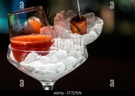 A glass of refreshing alcoholic beverage in a glass filled with ice cubes Stockfoto