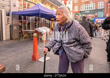 London, Großbritannien. Alte Frau mit einem Gehstock in der Gerrard Street, Chinatown Stockfoto