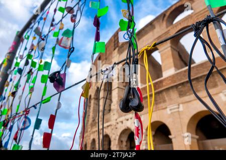 Entsorgte Kopfhörer, die von Touristen an einem Zaun vor dem Kolosseum in Rom, Italien benutzt wurden Stockfoto