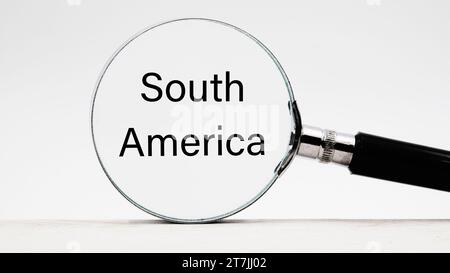 Phrase Südamerika durch eine Lupe auf hellem Hintergrund. Business- und Reisekonzept. Stockfoto