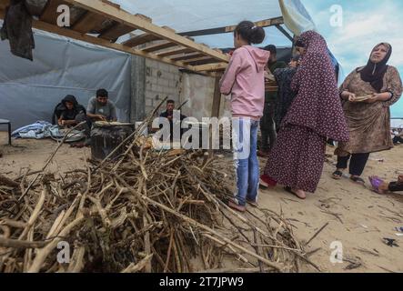 Gaza, Palästina. November 2023. Die Palästinenser machen Brot in einem „Make-Schichtunterkünften“ in Khan Yunis im südlichen Gazastreifen. Tausende von Zivilisten, sowohl Palästinenser als auch Israelis, sind seit dem 7. Oktober 2023 gestorben, nachdem palästinensische Hamas-Militante im Gazastreifen in den Süden Israels einmarschierten, bei einem beispiellosen Angriff, der einen Krieg auslöste, den Israel gegen die Hamas mit Vergeltungsbomben auf Gaza erklärt hatte. Quelle: SOPA Images Limited/Alamy Live News Stockfoto