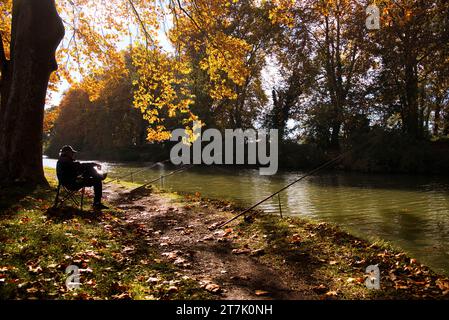 un pêcheur à la ligne sur les berges du Canal du Midi par un matin d'automne ein Angler am Ufer des Canal du Midi an einem sonnigen Herbst Stockfoto