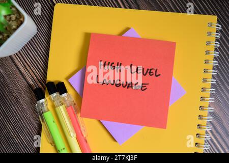 Konzept der High-Level-Sprache Schreiben Sie auf Haftnotizen, die auf Holztisch isoliert sind. Stockfoto
