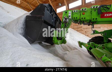 Chemnitz, Deutschland. November 2023. Ein Radlader sammelt Streusalz in der Salzhalle des Autobahnwartungswerks Chemnitz. Die sächsischen Straßenbauwerke sind gut auf den kommenden Winter vorbereitet. Um den Verkehr auf der über 500 Kilometer langen Autobahn bei Frost und Schnee aufrecht zu erhalten, stehen 64 Fahrzeuge und gut 230 Mitarbeiter bereit. Dazu gehört auch ein Bestand von über 15.000 Tonnen Streusalz. Quelle: Hendrik Schmidt/dpa/Alamy Live News Stockfoto