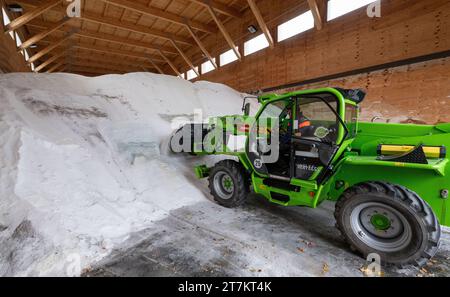 Chemnitz, Deutschland. November 2023. Ein Radlader sammelt Streusalz in der Salzhalle des Autobahnwartungswerks Chemnitz. Die sächsischen Straßenbauwerke sind gut auf den kommenden Winter vorbereitet. Um den Verkehr auf der über 500 Kilometer langen Autobahn bei Frost und Schnee aufrecht zu erhalten, stehen 64 Fahrzeuge und gut 230 Mitarbeiter bereit. Dazu gehört auch ein Bestand von über 15.000 Tonnen Streusalz. Quelle: Hendrik Schmidt/dpa/Alamy Live News Stockfoto
