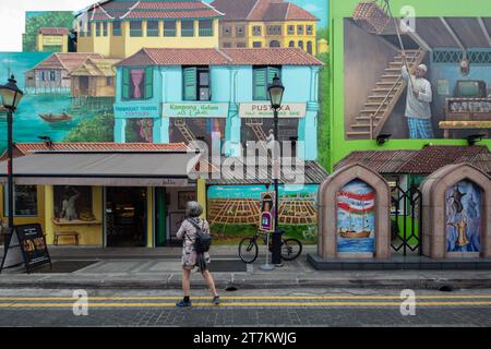 Besucher sehen sich das farbenfrohe Wandgemälde an, das die Geschichte und Kultur von Kampong Glam darstellt, gemalt vom Künstler Yip Yew Chong. Singapur. Stockfoto