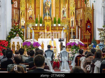 Ein vietnamesischer katholischer Priester ist Offizier und Zelebrant einer Hochzeit in der St. Joseph's Cathedral in Hanoi, Vietnam. Stockfoto