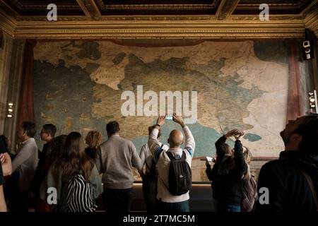 Eine vielfältige Gruppe von Menschen, die das Museum in Florenz, Italien, besuchen und sich um eine große Karte versammeln Stockfoto