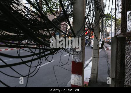 Chaotische Kabel und Drähte an einem Elektromast in Thailand, Stromversorgung in Städten mit häufigen Hurrikanen und Taifunen, Stromsicherheit. Stockfoto