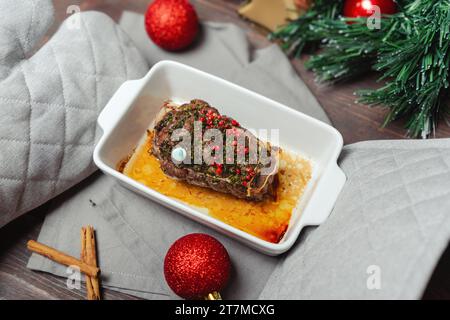 Heißes geröstetes Rindfleischgericht zum Weihnachtsessen. Festliches Weihnachtsmenü. Hände in Topflöchern halten geröstetes Rindfleisch Stockfoto