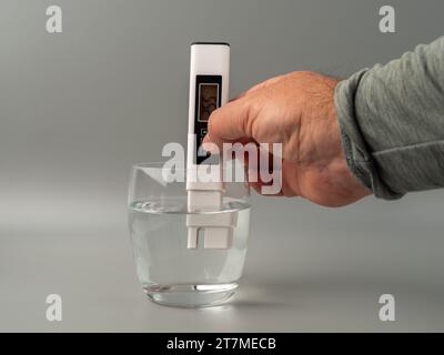 Wasserqualitätsprüfer auf grauem Hintergrund. Gerät zur Messung der Wasserqualität. Stockfoto