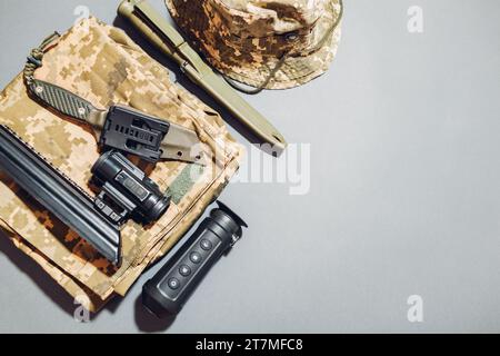 Militär-Ausrüstung FlatLay-Modell. Armee-Uniformkleidung, optische Sicht für Gewehr, Wärmebildkamera, Messer, Sonnenhut-Boonie. Leerraum. Draufsicht Stockfoto