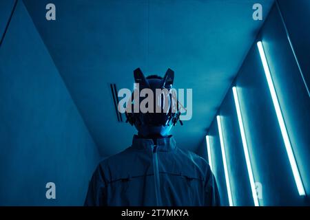Porträt einer Person mit Cyberpunk-Robotermaske in blauem Neonlicht, Kopierraum Stockfoto