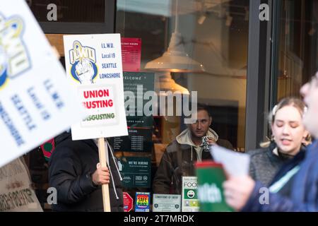 Seattle, USA. November 2023. Demonstranten und Verbündete vor dem ikonischen 1st and Pike Starbucks Store gegenüber dem geschäftigen Pike Place Market im Herzen der Innenstadt von Seattle. Der bundesweite Red Cup Rebellion Strike beginnt heute. Die Arbeiter protestieren gegen unfaire Arbeitspraktiken, da im ganzen Land immer mehr Geschäfte zur Gewerkschaft wechseln. Hunderte von Red Cup Rebellion-Streiks in Starbucks Stores sind heute im ganzen Land geplant, was den größten Starbucks-Streik in der Geschichte darstellt. Quelle: James Anderson/Alamy Live News Stockfoto