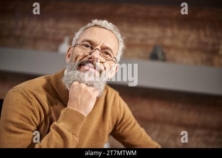 Porträt eines gutaussehenden Psychologen mittleren Alters in einer Brille, die während der Therapiesitzung in die Kamera blickt Stockfoto