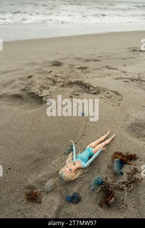 Eine weibliche Spielzeugpuppe mit langen blonden Haaren wird am Strand im Atlantik, Cocoa Beach, Florida, USA, gespült Stockfoto