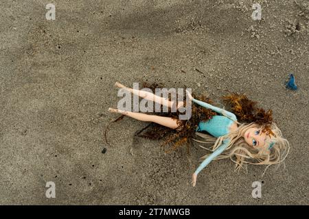 Eine weibliche Spielzeugpuppe mit langen blonden Haaren wird am Strand im Atlantik, Cocoa Beach, Florida, USA, gespült Stockfoto