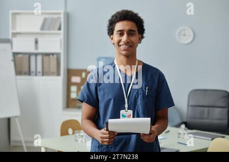 Porträt eines jungen arabischen Mannes, der in Uniform schrubbt und in der Klinik ein Klemmbrett hält, Kopierraum Stockfoto