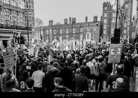 Eine Schwarzweißaufnahme einer großen Menge Demonstranten, die durch eine Stadtstraße in London marschieren. Stockfoto