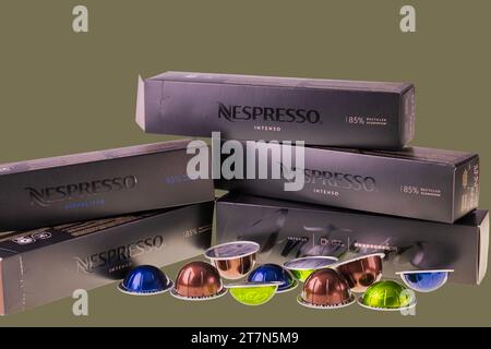 Nahaufnahme von Nespresso-Kaffeekapseln mit Pappkartons isoliert auf grün-schwarzem Hintergrund. Schweden. Stockfoto