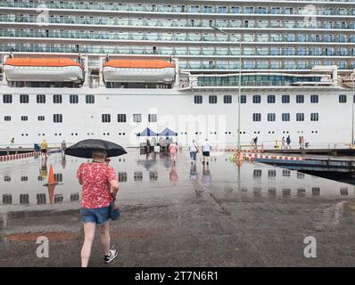 Menschen, die am Kai in Richtung eines großen britischen Kreuzfahrtschiffes auf den Westindischen Inseln im Regen im Januar 2023 gingen Stockfoto