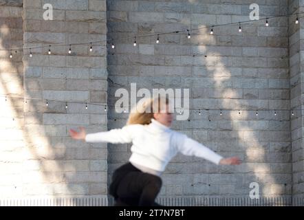 New York City, Usa. November 2023. Der kanadische Ice Dance Champion, World Medaillengewinner und Olympiasieger Kaitlyn Weaver führt eine Skating-Routine durch, als die erste Eislaufbahn im Brooklyn Bridge Park „Glide at Brooklyn Bridge Park“ offiziell für die Saison unter der historischen Brooklyn Bridge in New York City am Donnerstag, den 16. November 2023 eröffnet wird. Foto: John Angelillo/UPI Credit: UPI/Alamy Live News Stockfoto