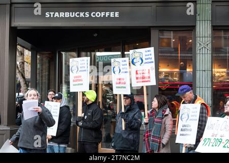 Seattle, USA. November 2023. Demonstranten und Verbündete vor dem ikonischen 1st and Pike Starbucks Store gegenüber dem geschäftigen Pike Place Market im Herzen der Innenstadt von Seattle. Der bundesweite Red Cup Rebellion Strike beginnt heute. Die Arbeiter protestieren gegen unfaire Arbeitspraktiken, da im ganzen Land immer mehr Geschäfte zur Gewerkschaft wechseln. Hunderte von Red Cup Rebellion-Streiks in Starbucks Stores sind heute im ganzen Land geplant, was den größten Starbucks-Streik in der Geschichte darstellt. Quelle: James Anderson/Alamy Live News Stockfoto