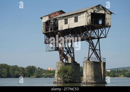 Esztergom, Ungarn 09.09.2023: Verlassener Kohlelader in der Donau. Elhagyo, Rozsdas, Veszelyes, omladozo, szenrakodo Stockfoto