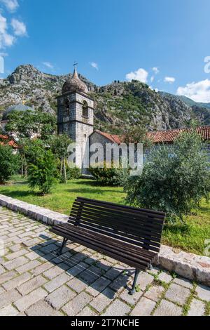 Bank vor dem Glockenturm der Kirche Saint Clare in der Altstadt von Kotor, Montenegro. Stockfoto