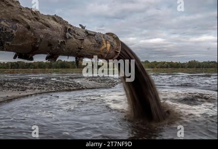 Raffinationsrohr, das in den Fluss fließt Stockfoto
